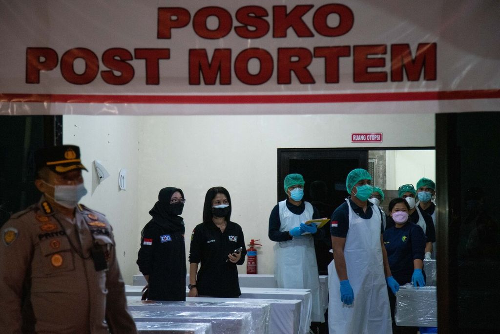 Polisi dan petugas medis di posko <i>post mortem </i>Rumah Sakit Bhayangkara Polda Kepulauan Riau menerima kepulangan jenazah pekerja migran dari Malaysia, Kamis (23/12/2021). 