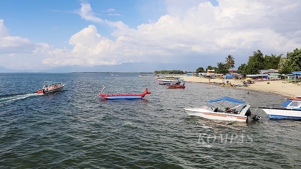 Wisatawan  menikmati Danau Toba di Pantai Pasir Putih Lumban Bulbul, Kecamatan Balige, Kabupaten Toba Samosir, Sumatera Utara, Jumat (9/6).