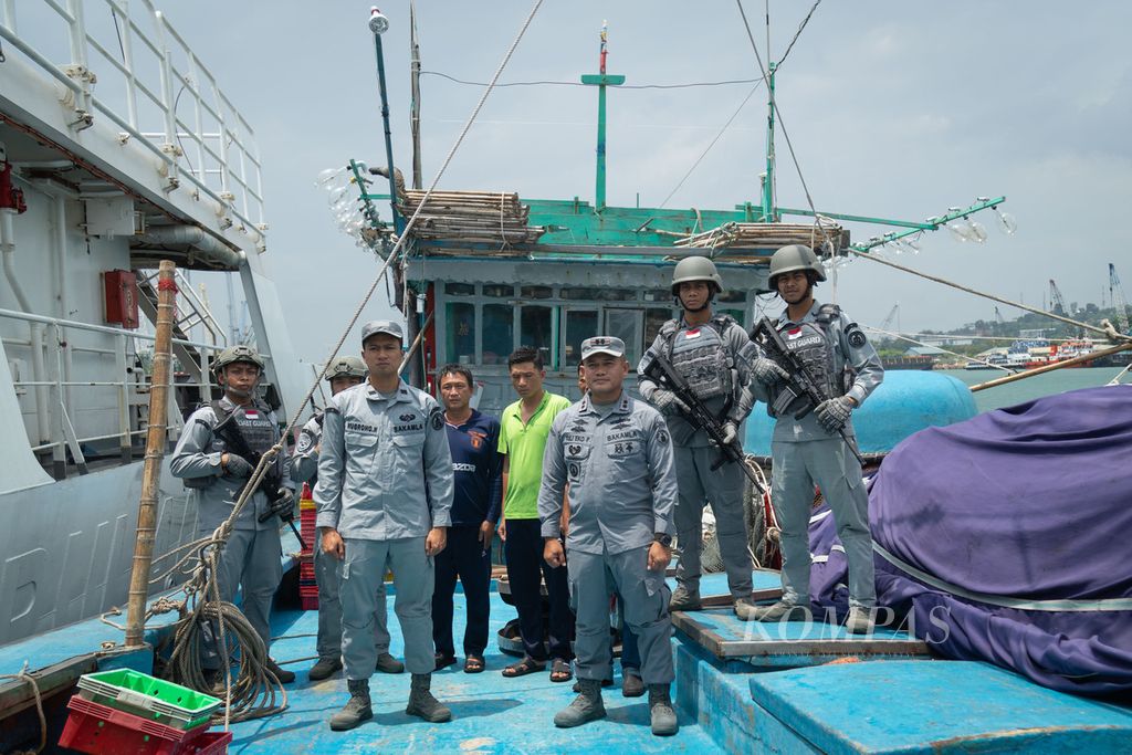 Petugas Badan Keamanan Laut RI menyeret kapal ikan Vietnam yang melakukan <i>illegal fishing </i>ke Batam, Kepulauan Riau, Senin (14/8/2023). Kapal itu sebelumnya ditangkap di Laut Natuna Utara pada 11 Agustus lalu.