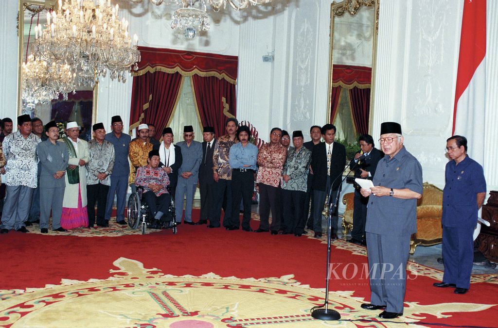 Presiden Soeharto memberikan keterangan pers seusai pertemuan dengan para ulama, tokoh masyarakat, organisasi kemasyarakatan, dan ABRI di Istana Merdeka, 19 Mei 1998, dua hari sebelum mengundurkan diri sebagai presiden. Turut menyaksikan Mensesneg Saadillah Mursyid (kanan) dan para tokoh, antara lain Yusril Ihza Mahendra, Amidhan, Nurcholish Madjid, Emha Ainun Najib, Malik Fadjar, Sutrisno Muchdam, Ali Yafie, Ma’ruf Amin, Abdurrahman Wahid, Cholil Baidowi, Adlani, Abdurrahman Nawi, dan Ahmad Bagdja. 