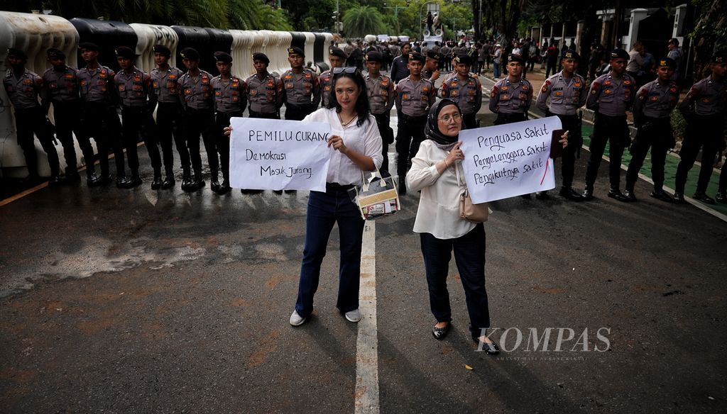 Peserta demonstran membawa poster di sekitar Kantor Komisi Pemilihan Umum (KPU), Jakarta, mengkritisi Pemilu 2024, Jumat (16/2/2024). Sejumlah elemen masyarakat menggelar aksi memprotes KPU terkait pelaksanaan Pemilu 2024.