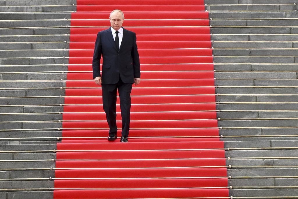 Presiden Rusia Vladimir Putin berjalan di tangga yang ditutupi karpet merah di Kremlin, Moskwa, Selasa (27/6/2023). Tidak hanya memberi penghormatan pada prajurit yang tewas dalam pemberontakan kelompok Wagner, Putin menyebut pemimpin pemberontak terlibat dalam tindakan kriminal yang memecah dan melemahkan negara.  