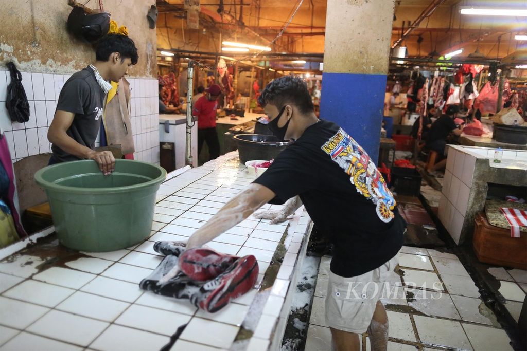 Pedagang ikan mencuci lapak dan perkakasnya dengan air sabun seusai berdagang di Pasar Palmerah, Jakarta, yang baru dibuka kembali, Minggu (28/6/2020).