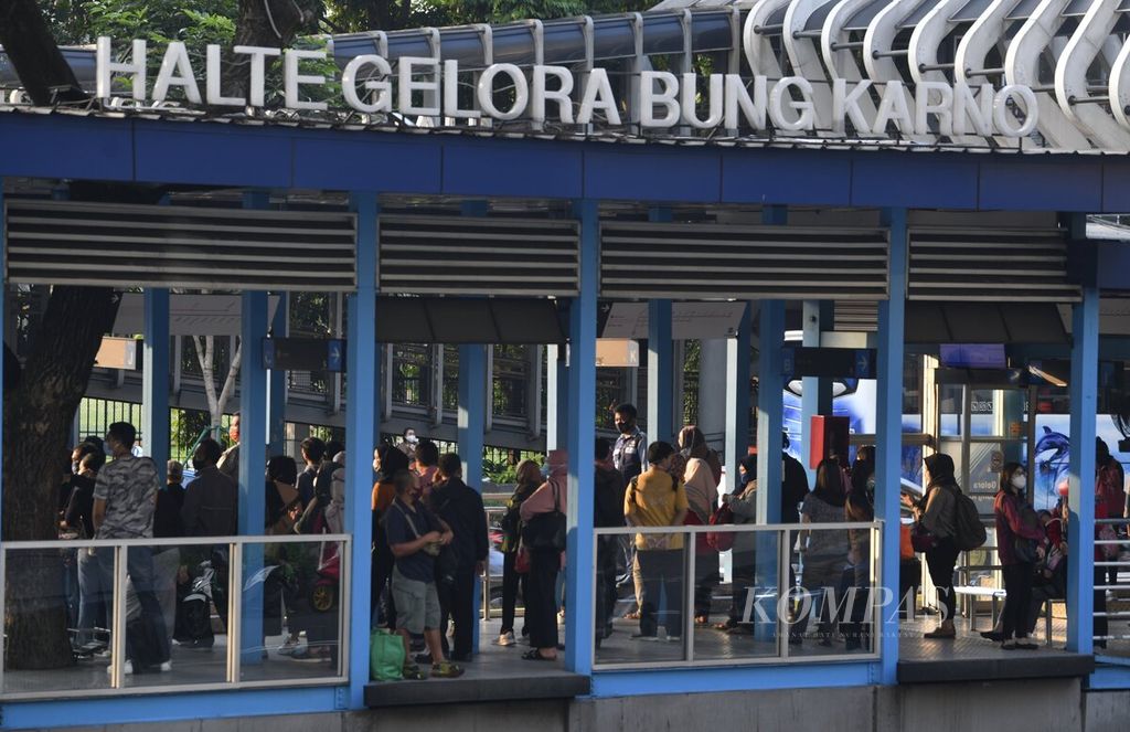 Para pekerja menunggu bus Transjakarta di Halte Gelora Bung Karno, Jakarta, saat jam pulang kerja, Rabu (19/8/2020). 