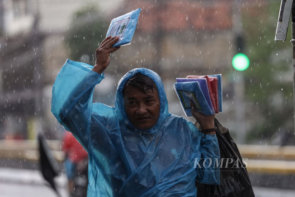 Raincoat vendors seek buyers on Jatinegara Barat Street, Jakarta on Monday (3/4/2024). The Meteorology, Climatology and Geophysics Agency predicts that the Jabodetabek region, some parts of southern Sumatra and Java Island are still in the peak of the rainy season, which could potentially cause extreme weather for up to a week.