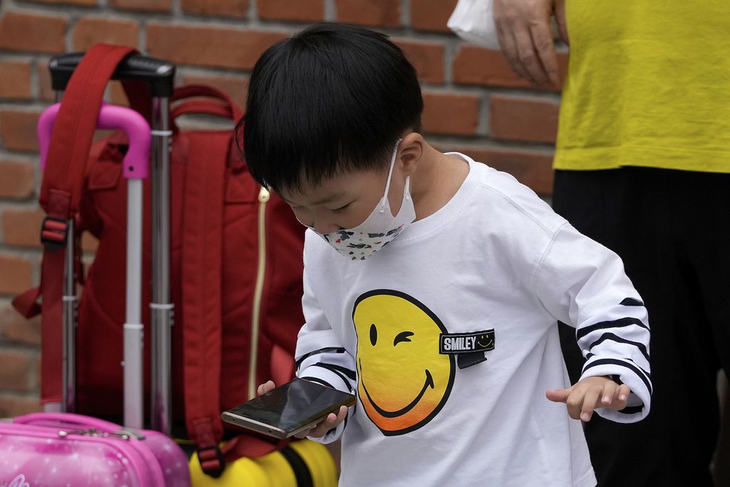 Seorang anak berusia kurang dari 10 tahun bermain gim daring di salah satu sudut kota Beijing, China, 12 September 2021. Pada Agustus 2023, CAC kembali mengusulkan pengetatan akses internet bagi remaja dan anak di bawah umur untuk mengatasi kecanduan gim atau layanan <i>video streaming</i>. 