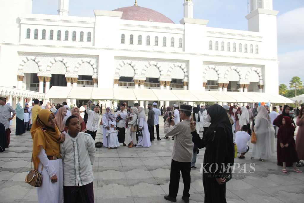 Jemaah mengabadikan foto kebersamaan dengan keluarga seusai shalat Idul Fitri di kompleks Masjid Raya Mujahidin, Pontianak, Kalimantan Barat, Senin (2/5/2022).