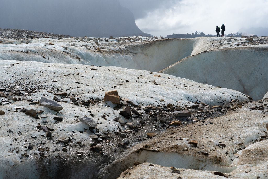 Scientists work on top of Exploradores glacier, in the region of Aysen, southern Chile, on February 14, 2022. - The melting of the glaciers is a natural phenomena which climate change has accelerated significantly, told AFP Jorge O'Kuinghttons, chief of the Regional Unit of Glaciology of the General Water Directorate (DGA). 