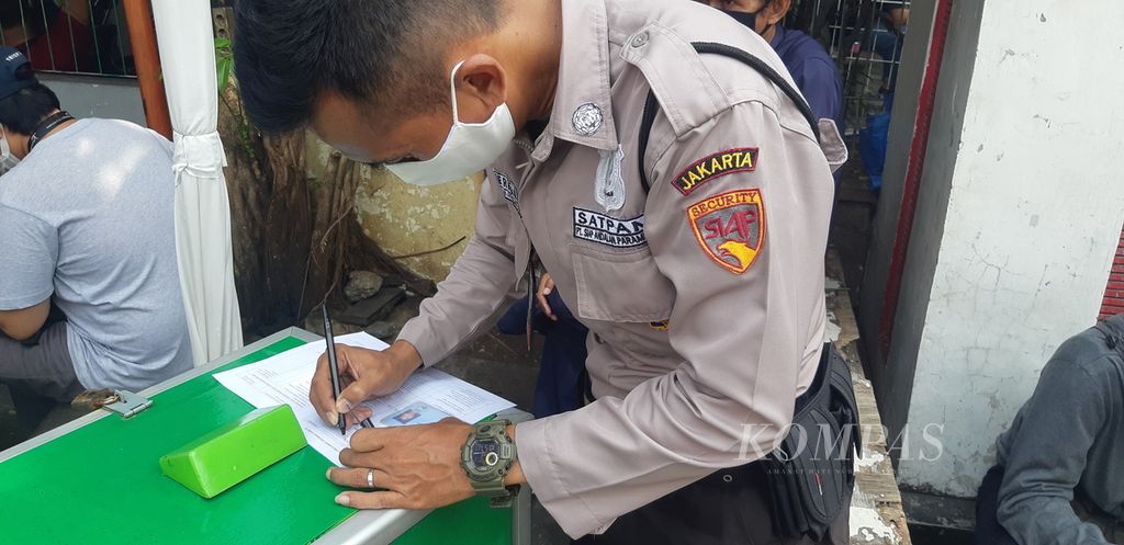 Seorang anggota satpam mengisi formulir untuk mengikuti vaksinasi Covid-19 gratis di RW 002 Kelurahan Gelora, Tanah Abang, Jakarta Pusat, Senin (14/6/2021).