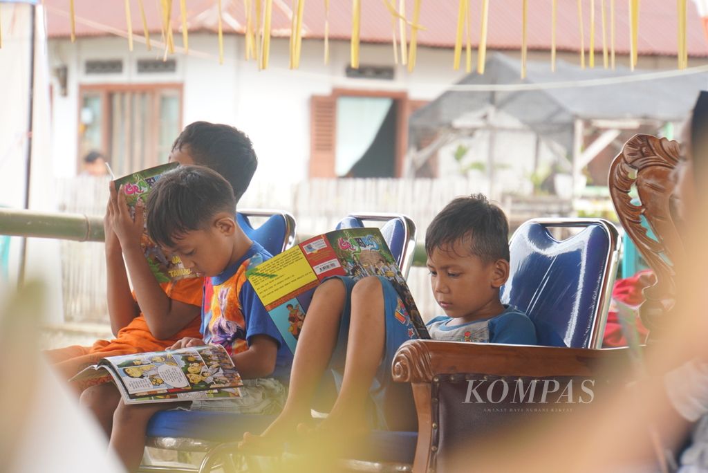 Anak-anak Desa Vahuta, Bintauna, Bolaang Mongondow Utara, Sulawesi Utara, membaca buku-buku koleksi Taman Bacaan Masyarakat Teras Inomasa, Sabtu (13/11/2021).