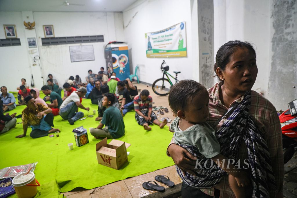 Warga terdampak ledakan gudang amunisi daerah Kodam Jayakarta menggendong anaknya di posko pengungsian di Ciangsana, Kabupaten Bogor, Jawa Barat, Minggu (31/3/2024).