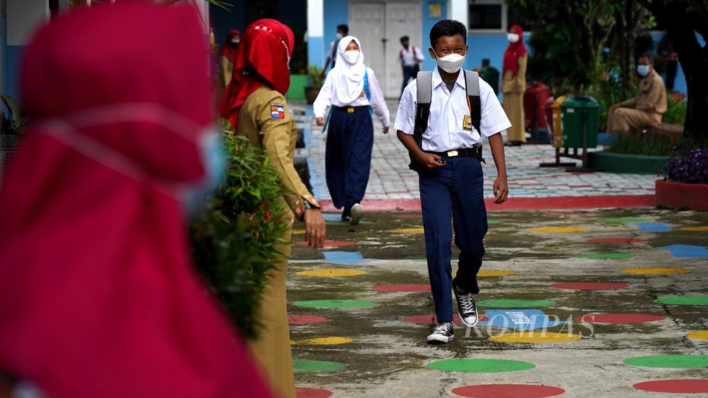 Penerapan pengaturan jarak berjalan para siswa SMP Negeri 15 Kota Bogor, Jawa Barat, ketika pulang sekolah setelah pelaksanaan uji coba pembelajaran tatap muka (PTM), Senin (31/5/2021). 