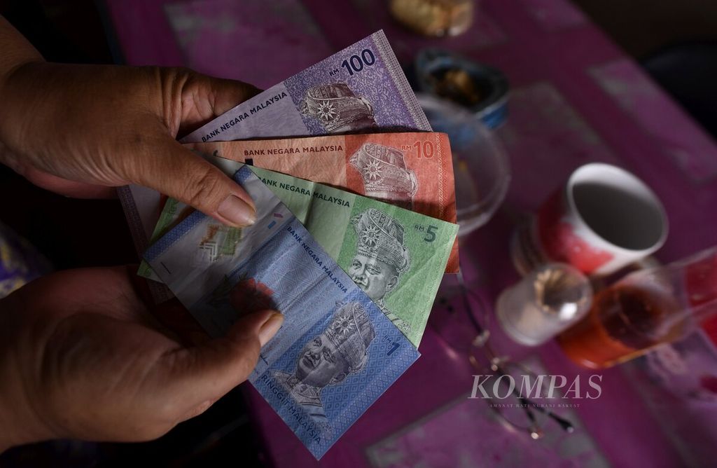 Salah seorang warga menunjukkan sejumlah uang ringgit Malaysia di Desa Aji Kuning, Sebatik, Kabupaten Nunukan, Kalimantan Utara, Jumat (15/7/2022). 