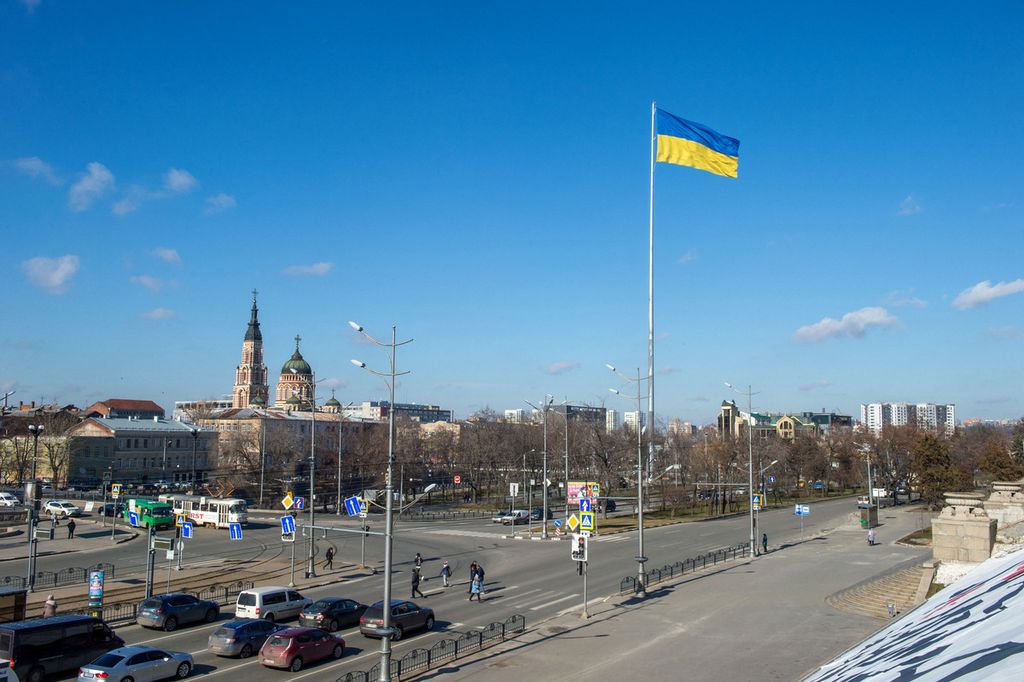 Bendera nasional Ukraina berkibar di pusat kota terbesar kedua di Ukraina, Kharkiv, sekitar 40 km dari perbatasan Ukraina-Rusia, Senin (21/2/2022). Ukraina meminta pertemuan mendesak Dewan Keamanan PBB untuk mengatasi ancaman invasi Rusia sebagai jaminan keamanan yang diterimanya sebagai imbalan karena menyerahkan persenjataan nuklirnya pada tahun 1994.