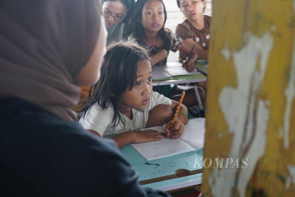 Najwa (8), peserta Kelas Mengajar yang diselenggarakan Komunitas Dinding Manado, menyalin tulisan di papan tulis di lantai 3 gedung utama Pasar Bersehati Manado, Sulawesi Utara, Sabtu (11/11/2023). 
