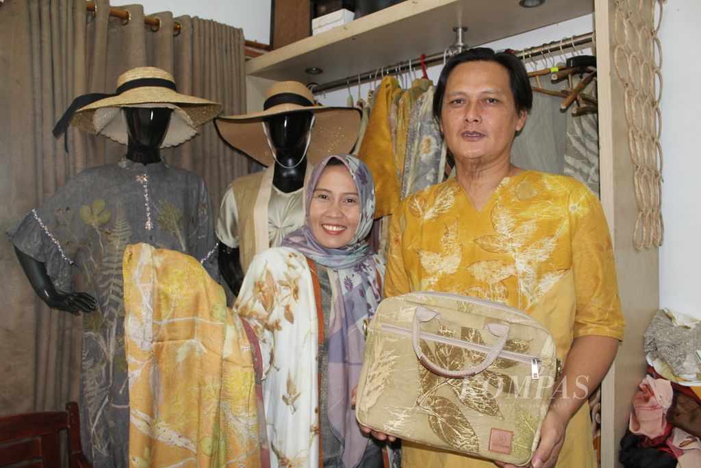 Yuli Hasan bersama suaminya, Iswahyudi, menunjukkan aneka produk Swarna Alam yang menggunakan teknik <i>ecoprint </i>di rumahnya di Jalan Ketilang Raya, Kecamatan Harjamukti, Kota Cirebon, Jawa Barat, Selasa (1/8/2023). Dengan <i>ecoprint</i>, Yuli membuat motif menggunakan bahan alam, seperti dedaunan. 