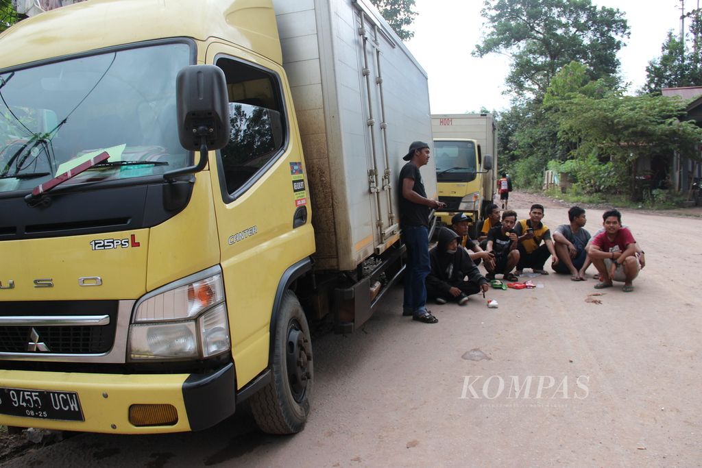 Para sopir logistik terjebak di Kecamatan Nanga Tayap, Kabupaten Ketapang, Kalimantan Barat, Rabu (12/10/2022), karena banjir. Jalan yang digenangi banjir di daerah tersebut merupakan jalur Trans-Kalimantan yang menghubungkan Kalbar dengan Kalimantan Tengah.