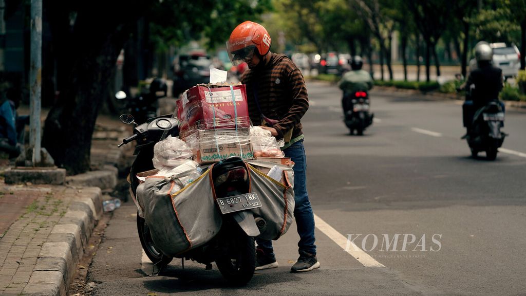 Kurir barang mengecek muatan di kawasan Cempaka Putih, Jakarta Pusat, Selasa (24/9/2021). Persoalan upah yang layak bagi para kurir, keselamatan para kurir selama bekerja merupakan hal mutlak yang perlu diperhatikan, baik oleh perusahaan penyedia layanan maupun pemerintah.