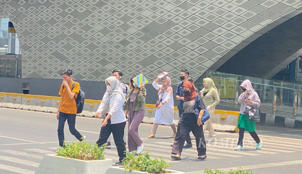 Sejumlah warga tengah menyeberang dari Halte TransJakarta Bundaran HI Astra, Jakarta Pusat, Selasa (10/10/2023) di tengah cuaca panas yang menyengat.