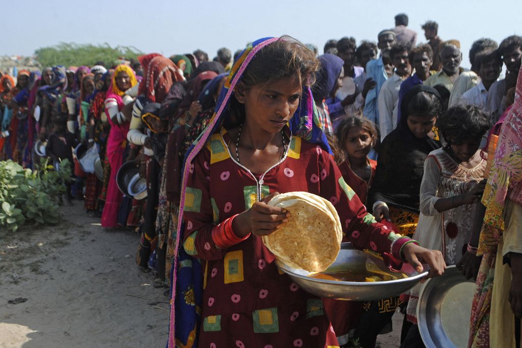 Korban bencana banjir mengantre untuk mendapatkan makanan di kamp pengungsian di Provinsi Sindh, Pakistan, Senin (19/9/2022). 