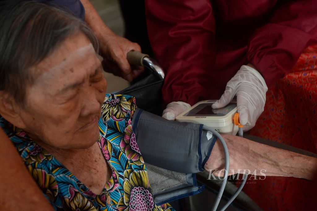 Petugas kesehatan memeriksa kesehatan salah satu warga lanjut usia yang akan mendapatkan vaksin lanjutan di Gang Pinggir, Kota Semarang, Jawa Tengah, Senin (7/3/2022). Vaksin lanjutan saat ini menjadi tumpuan untuk menghadapi ancaman tertularnya virus Covid varian baru. 