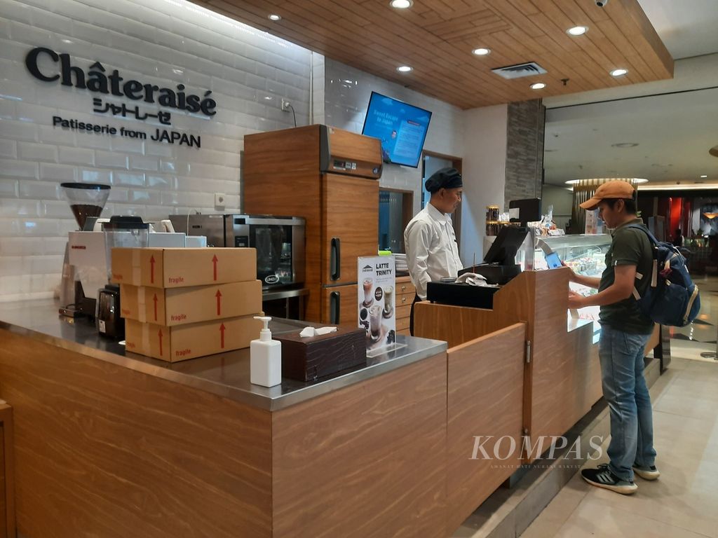 Kasir Châteraisé, Agung, melayani pelanggan di Mal Grand Indonesia, Jakarta, Kamis (8/2/2024). Saat Pemilu 2024, pihaknya memberikan kue moci gratis dengan pembelian produk minimal Rp 100.000. 