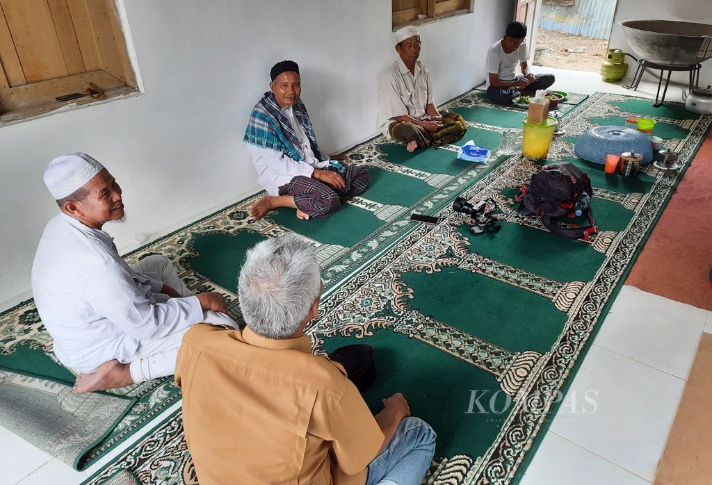 Buya Mudo Khalidi (dua dari kiri), mursyid dan pemimpin Tarekat Naqsabandiyah Khalidiyah di Surau Nurullah sedang berkumpul bersama para khalifah (asisten mursyid) di dapur surau, Kelurahan Limau Manis Selatan, Kecamatan Pauh, Padang, Sumatera Barat, Rabu (30/3/2022). Pada Ramadhan tahun ini ada 14 orang jemaah yang menjalankan suluk di surau tersebut.
