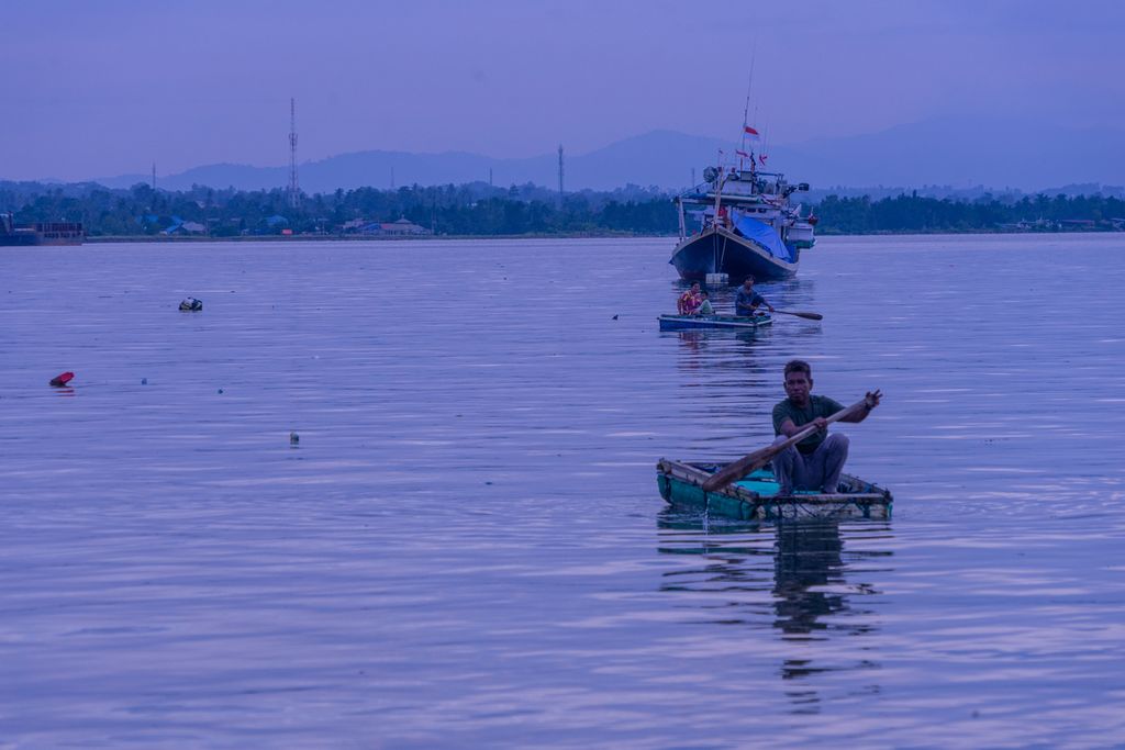 Sejumlah nelayan membawa barang untuk dipindahkan ke kapal di Teluk Kendari, Sulawesi Tenggara, Senin (28/3/2022). Nelayan kecil di wilayah ini menghadapi berbagai tantangan, utamanya dengan konflik jalur penangkapan yang telah diatur pemerintah.
