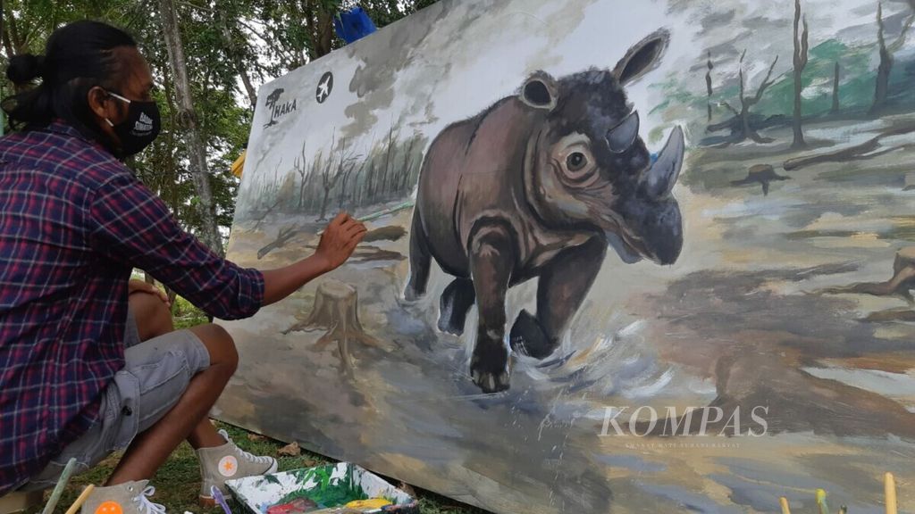 Seorang pelukis merampungkan lukisan badak dalam kegiatan kampanye perlindungan badak sumatera, memperingati Hari Badak Dunia, Rabu, (22/9/2021).  