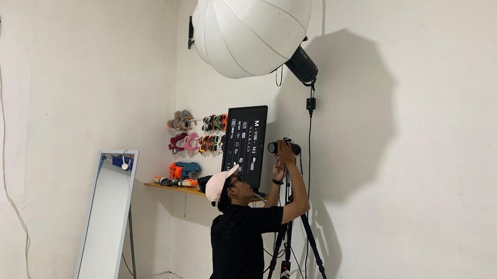 Muhammad Rayhan (24) adjusts the camera placement at the studio he runs with his partner named Rumafoto Studio in the Ciputat area of ​​South Tangerang, Banten, on Friday (10/5/2024). As they do not yet have employees, Rayhan single-handedly manages the studio from 10:00 AM to 8:00 PM every day.