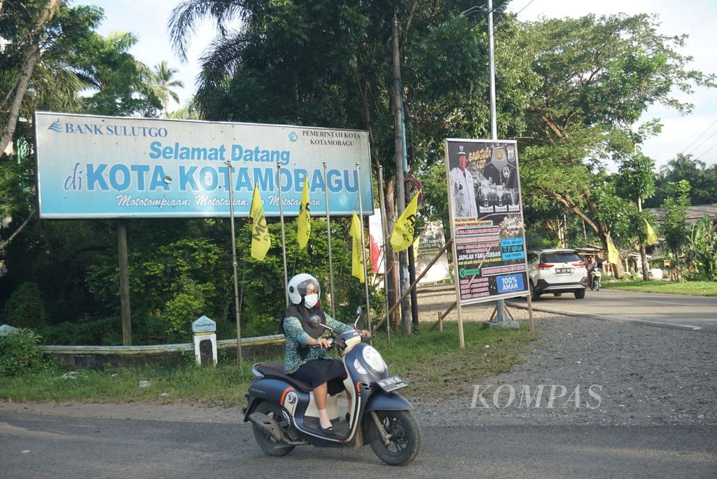 Pengemudi sepeda motor melintas di depan pintu kota Kotamobagu, Sulawesi Utara, pada Kamis (16/6/2022).