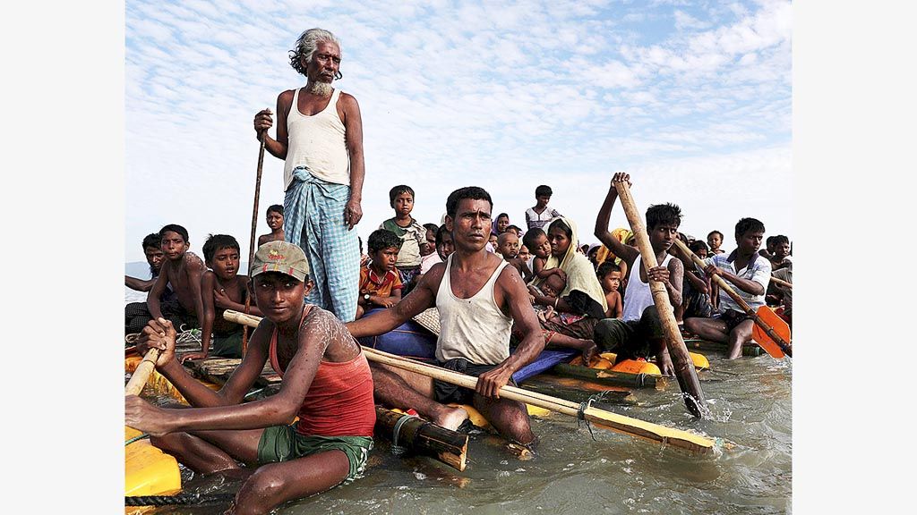 Para pengungsi Rohingya  menyeberangi Sungai Naf dengan rakit untuk mengungsi ke Teknaf, Bangladesh, Minggu (12/11).