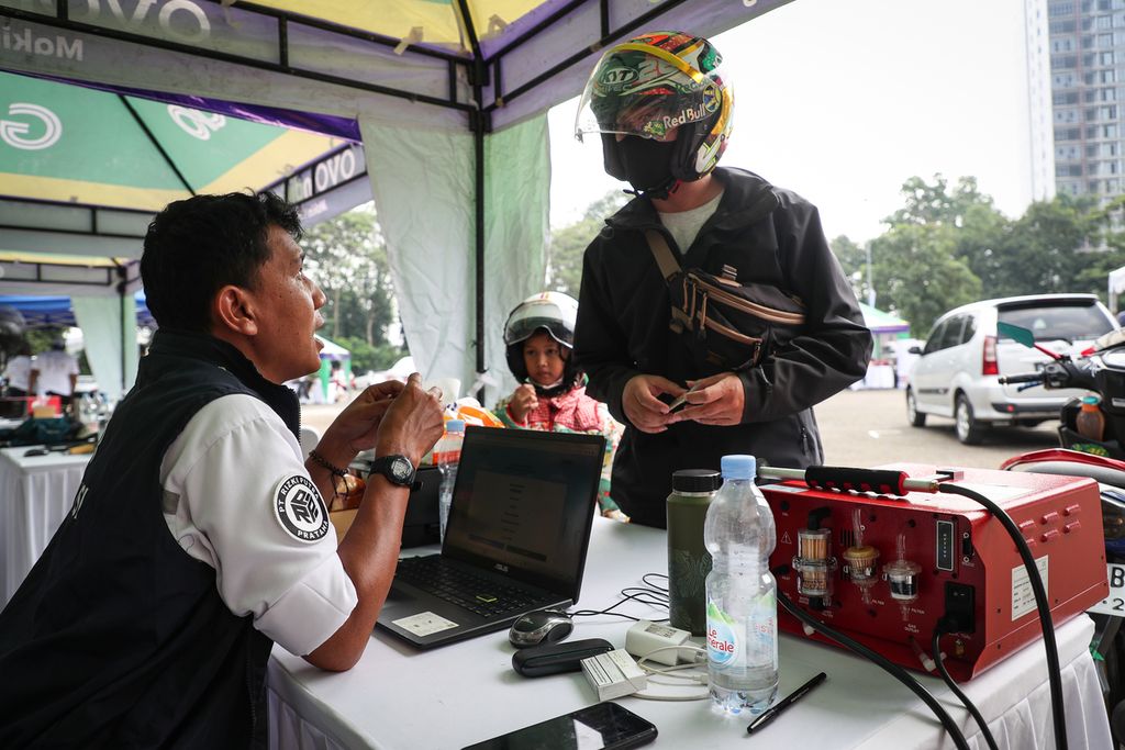 Petugas berbincang dengan pemilik kendaraan yang menjalani uji emisi gratis di Taman Margasatwa Ragunan, Jakarta, Senin (5/6/2023). 