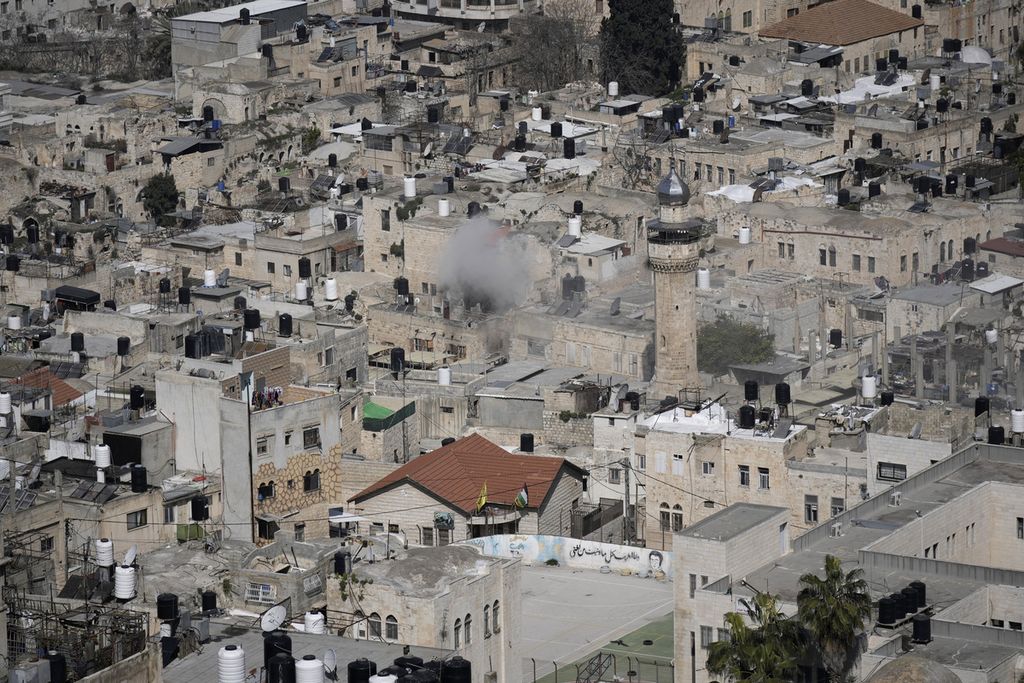 Asap mengepul dari sebuah bangunan di Nablus, Tepi Barat, Rabu (22/2/2023) saat militer Israel mengepung sebuah bangunan untuk menangkap sejumlah tersangka pembunuhan anggota militer israel. Sebanyak 11 orang warga Palestina tewas dan lebih dari 100 orang terluka dalam serangan tersebut. (AP Photo/Majdi Mohammed)