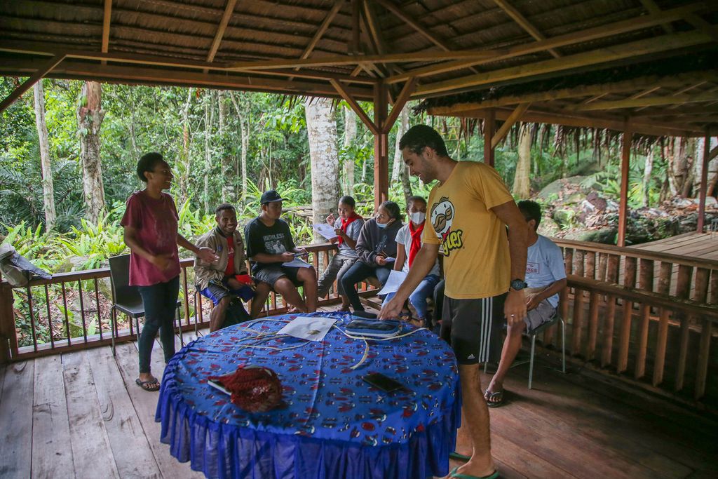 Sejumlah siswa Sekolah Alam Hirosi sedang menyimak pelajaran Bahasa Inggris dari Samuel, di kawasan Club Pecinta Alam Hiroshi, Sentani, Papua, Selasa (30/11/2021). 