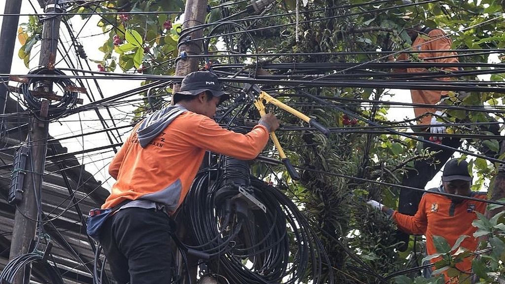 Petugas Dinas Pekerjaan Umum dan Perumahan Rakyat Kota Bogor menertibkan dan memotong jaringan kabel yang semrawut di Jalan Ahmad Yani, Kota Bogor, Jawa Barat.