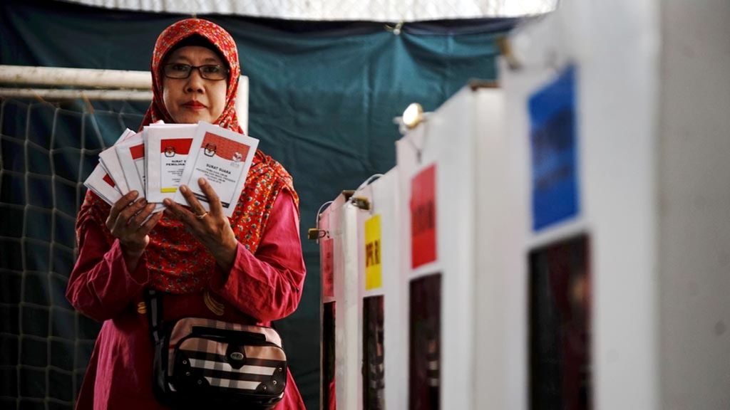 Warga menunjukkan surat suara seusai melakukan simulasi pemungutan suara di TPS 10 Pondok Cina Depok, Jawa Barat, Sabtu (23/3/2019). 