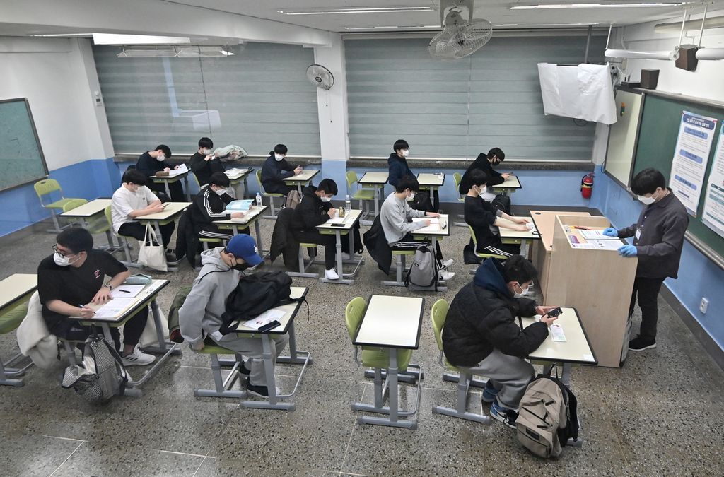 Pelajar mengikuti ujian <i>suneung</i> di sebuah sekolah di Seoul, Korea Selatan, Kamis (18/11/2021). Siswa yang mengikuti <i>suneung</i> harus dites Covid-19 dan yang menunjukkan gejala harus mengikuti ujian di tempat yang ditentukan secara terpisah. 