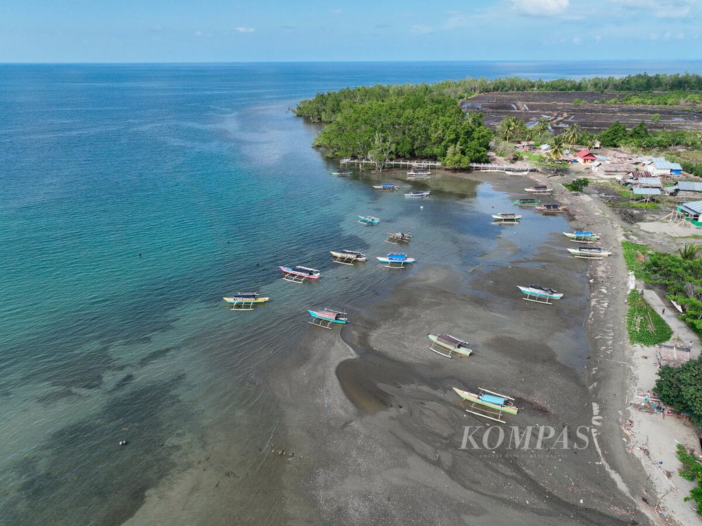 Perahu nelayan yang bersandar di tepi pantai dengan latar belakang perairan Teluk Tomini di Kabupaten Parigi Moutong, Sulawesi Tengah, Kamis (22/6/2023). 