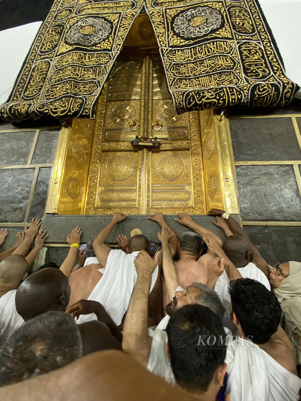 Worshippers attempt to touch the door of the Kaaba after performing the circumambulation or prayer while circling the Kaaba in the area of Masjid al-Haram, Mecca, Saudi Arabia, on Wednesday (14/6/2023) early morning. Circumambulation is a part of the Umrah ritual that is also performed by pilgrims while awaiting the hajj season.