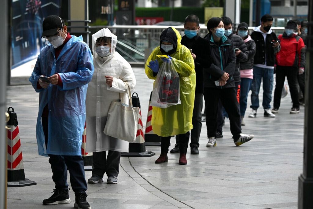 Orang-orang mengenakan masker wajah antri untuk memasuki sebuah supermarket di Wuhan, di provinsi Hubei tengah China, 30 Maret 2020.