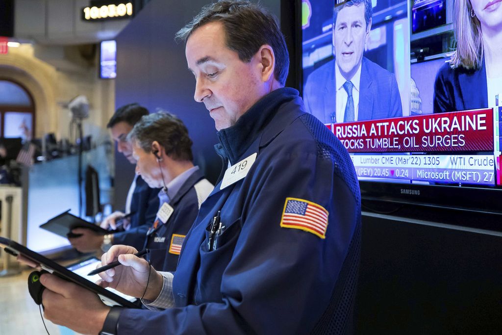 Dalam foto yang disediakan oleh Bursa Efek New York ini, para <i>trader</i> bekerja di lantai Bursa Efek New York, New York City, AS, 24 Februari 2022, sementara layar televisi di dekat mereka menyiarkan berita serangan Rusia ke Ukraina.