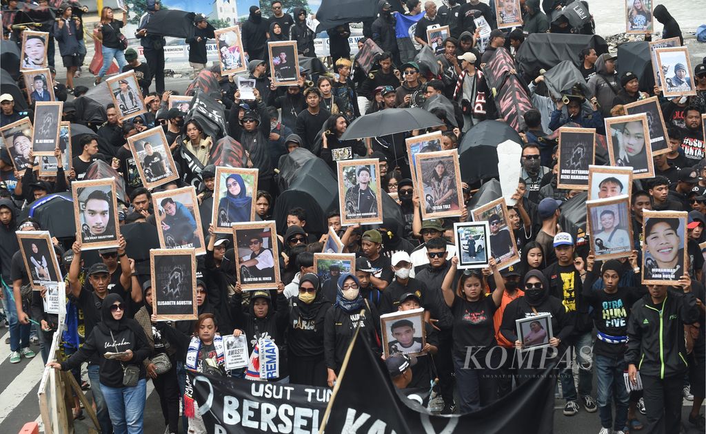 Kelompok suporter Arema (Aremania) membawa keranda jenazah dan foto para korban meninggal dalam Tragedi Kanjuruhan saat unjuk rasa Malang Menghitam di Kota Malang, Jawa Timur, Kamis (10/11/2022). 