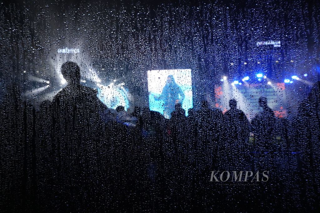 Bulir air dari kaca menetes saat grup band Ali tampil dalam Joyland Festival Jakarta 2023 di Stadion Baseball Gelora Bung Karno, Senayan, Jakarta, Jumat (24/11/2023). Di tengah hujan, sebagian penonton bertahan menikmati musik.