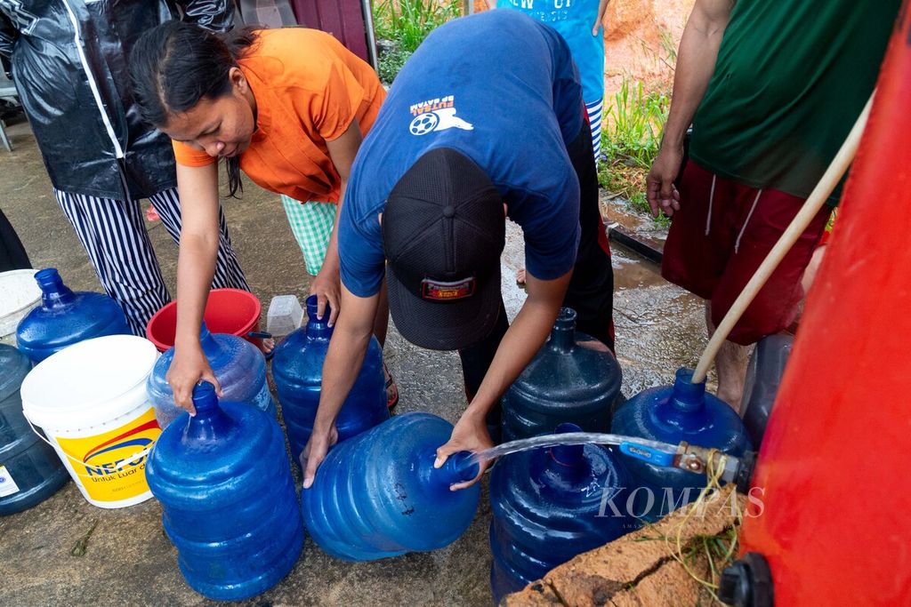 Warga mengantre untuk mengambil air yang disuplai oleh mobil tangki di Perumahan Bukit Raya, Kelurahan Belian, Kecamatan Batam Kota, Kota Batam, Kepulauan Riau, Senin (23/1/2023). 