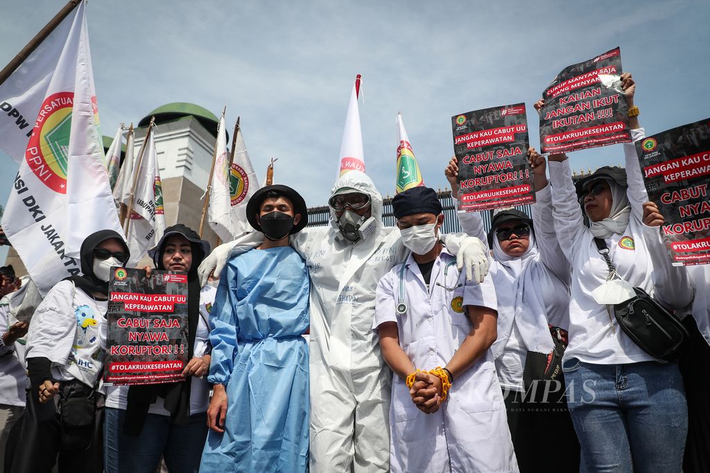 Aksi teatrikal dalam aksi menolak pengesahan Rancangan Undang-Undang (RUU) Kesehatan di depan Kompleks Parlemen, Jakarta, Selasa (11/7/2023). 