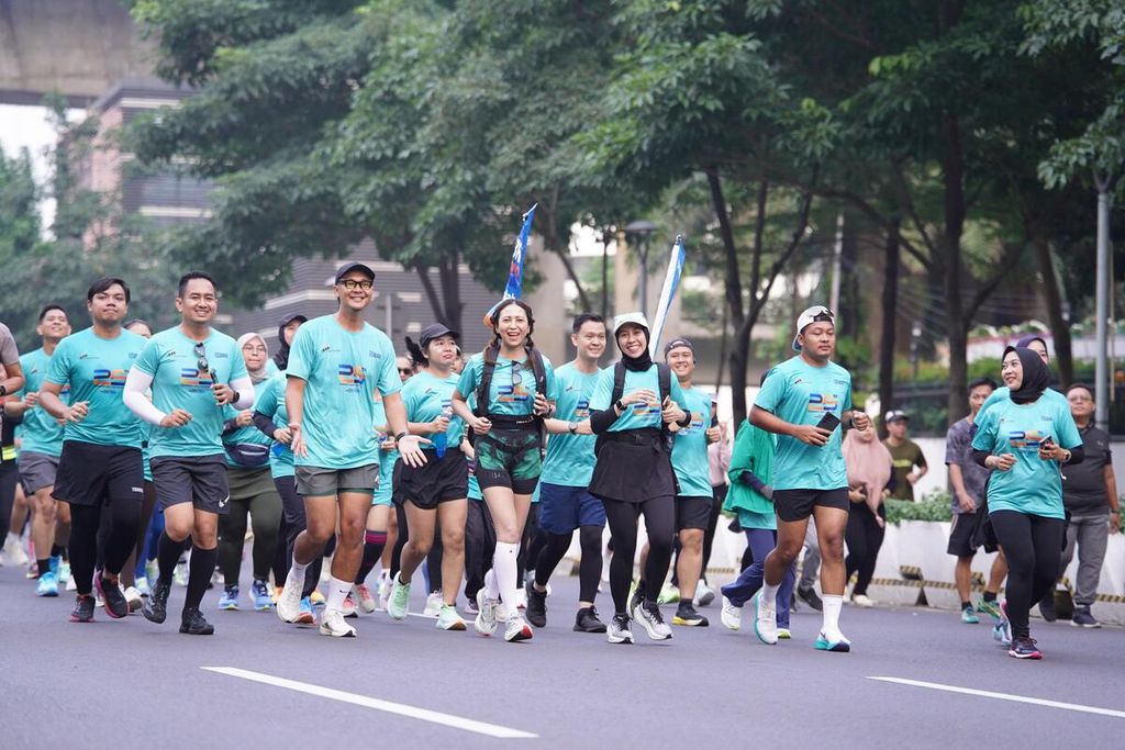 Para pelari dari BRI Runners berlari bersama pada hari bebas kendaraan bermotor di Jalan Sudirman-Thamrin, Jakarta, Minggu (2/5/2024) pagi.