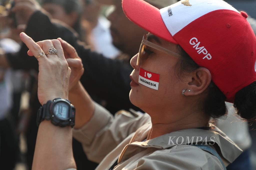Seorang menempelkan bendera merah putih pada pipi saat menunggu kedatangan bakal calon presiden dari Partai Gerindra, Prabowo Subianto, di rumah pemenangan sukarelawan Prabowo, Menteng, Jakarta Pusat, Selasa (15/8/2023).