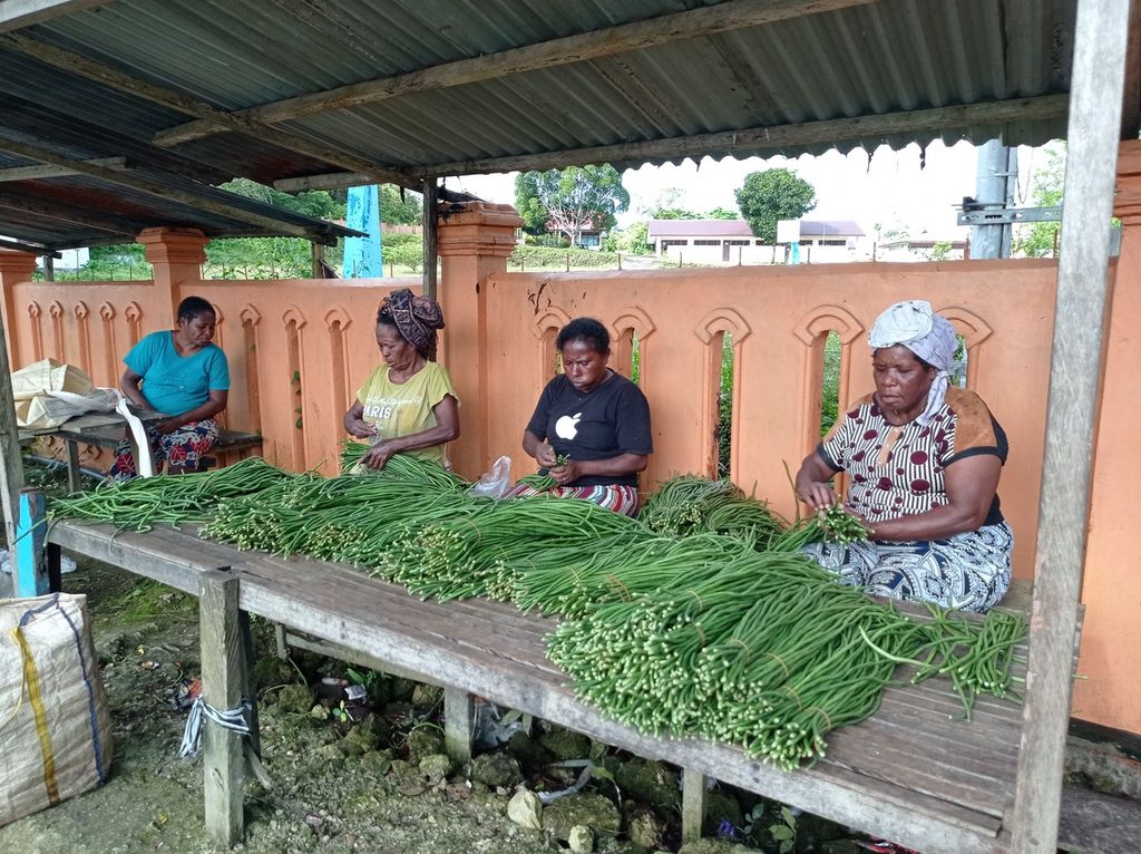 Mama-mama menyiapkan sayuran yang dijual di <i>yuuk ro raa masim boo</i> (lapak) di sepanjang tepi Jalan Poros Ayamaru-Kumurkek, ruas Jalan Trans-Papua Barat, Rabu (13/7/2022).