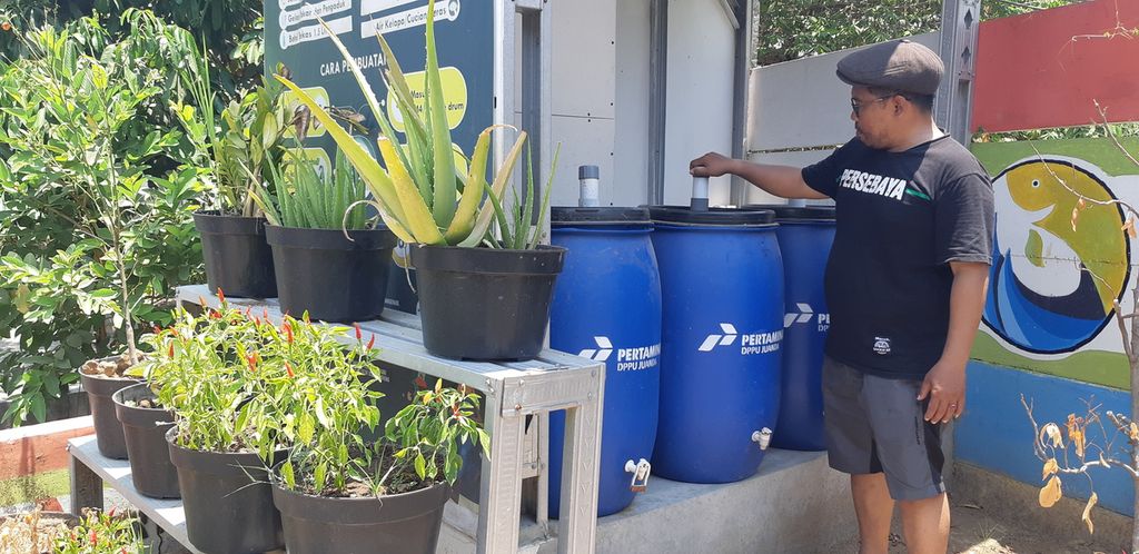 Ahmad Arif Wibowo menunjukkan tempat penampungan air limbah pencucian ikan bandeng, Minggu (29/10/2023). Warga Desa Kalanganyar , Sidoarjo, memproduksi pupuk organik cair dari air limbah cucian ikan bandeng.